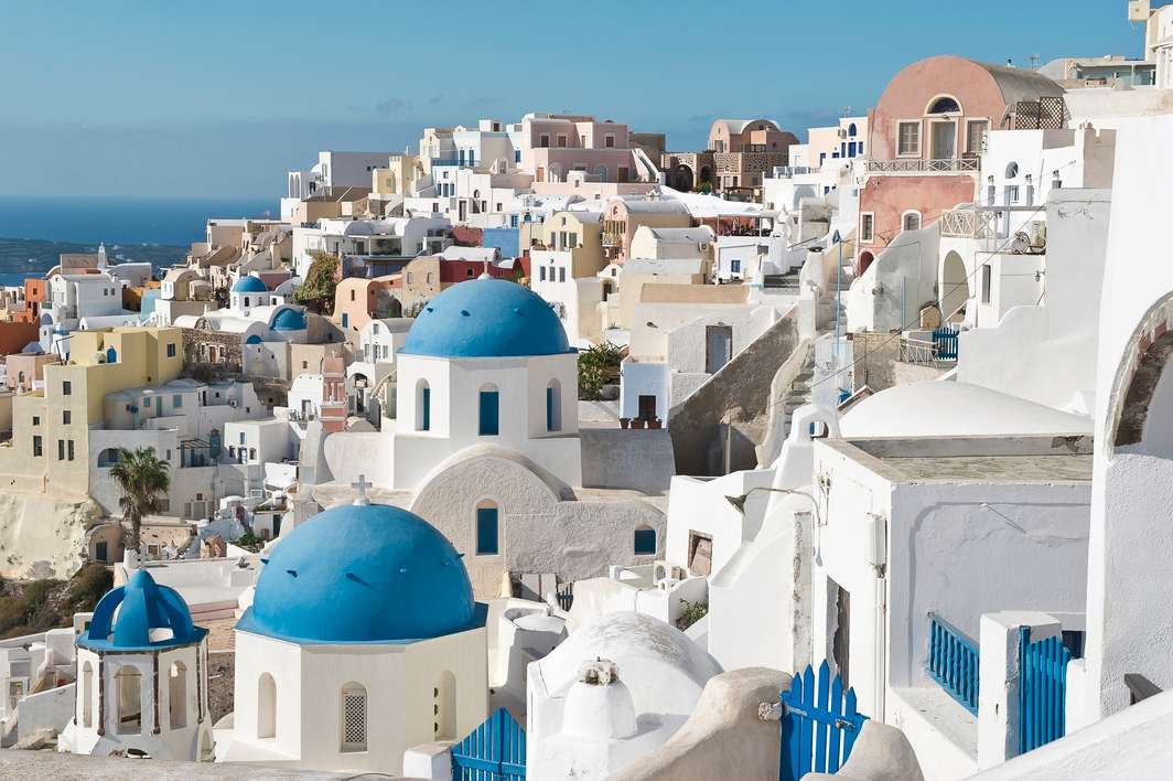 Blue-domed churches and whitewashed buildings overlooking the sea in Oia, Santorini
